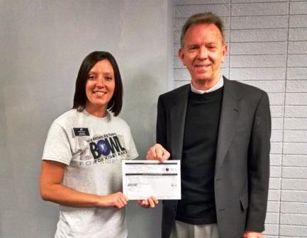 Presenting a representative from Big Brothers Big Sisters with a check from the proceeds raised at Bowl For Kids’ Sake event.