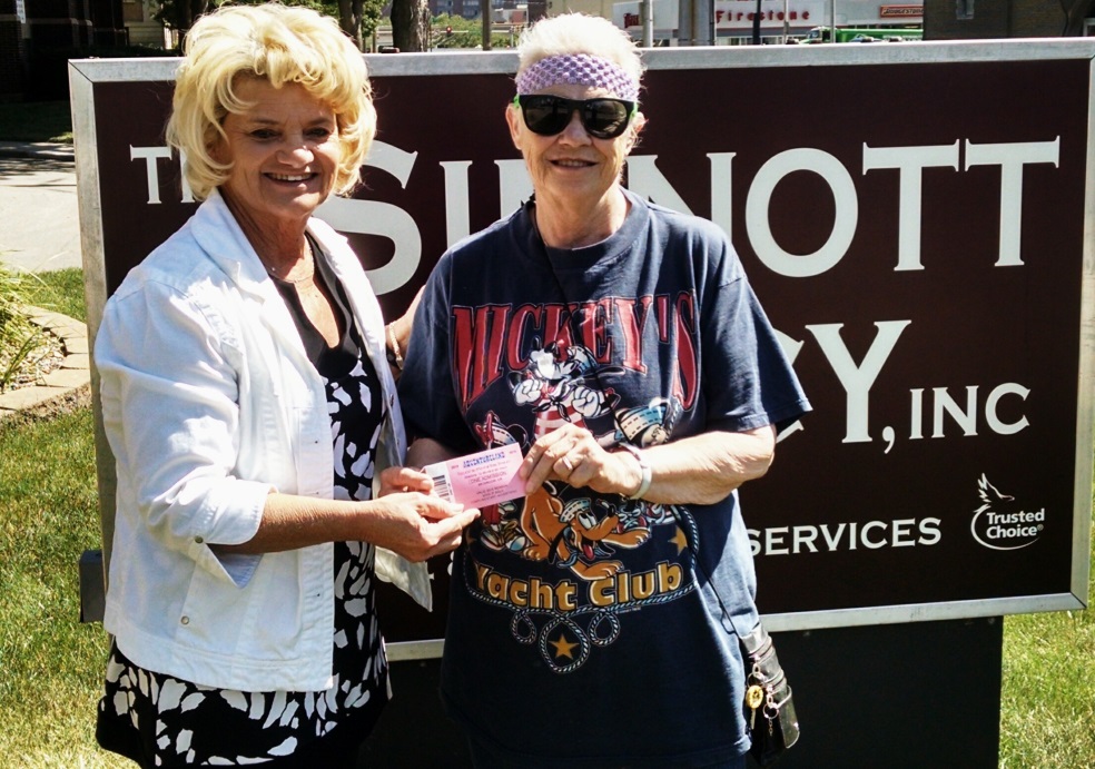 Joanne and Pam pose in front of The Sinnott Agency sign.